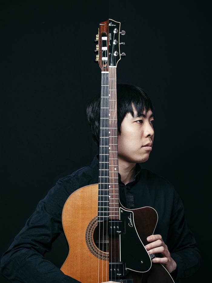 Porträt von Fu Ping Ryu mit einer klassischen und einer Archtop-Gitarre